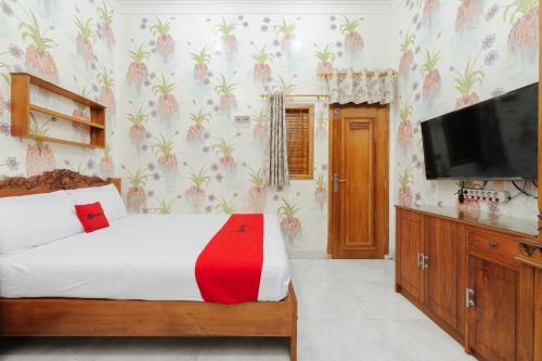 a bedroom with a bed and a flat screen tv at RedDoorz Plus near Mall Sunter in Jakarta