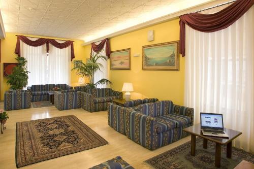 a living room with couches and a laptop on a table at Hotel Florida in Montecatini Terme