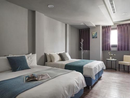 a hotel room with two beds and a table at Mr.Mantter in Taichung