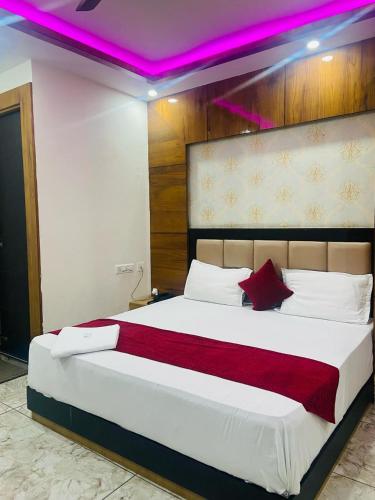 a bedroom with a large bed with a purple lighting at preferred hotel and restaurant in Roorkee