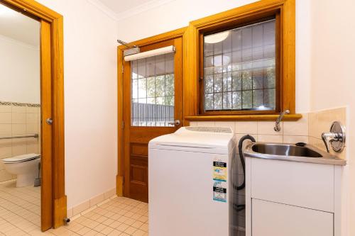 a small kitchen with a sink and a toilet at Olive Hideaway in Albury