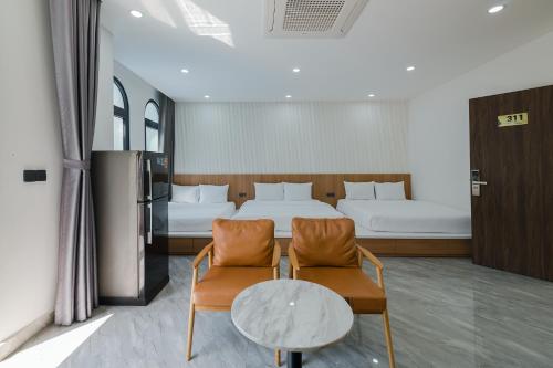 フーコックにあるLalisa Hotel Grand World Phu Quocのベッド1台、椅子2脚、テーブルが備わる客室です。