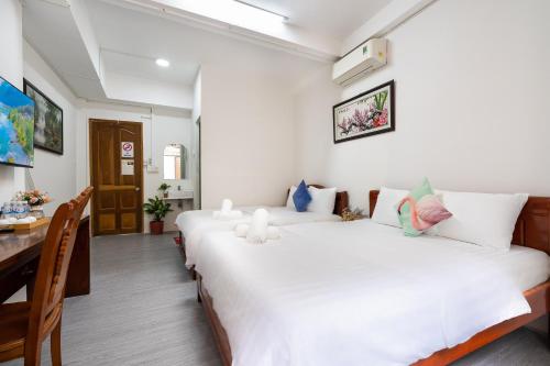 a bedroom with two beds and a table and a dining room at Galaxy Bùi Viện Home in Ho Chi Minh City