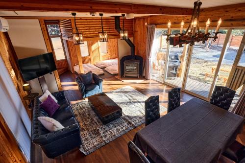 a living room with a couch and a table and a fireplace at -Light House- 那須中心エリアの道の駅から徒歩圏内で那須塩原駅からバスでも行ける完全プライベート貸切ログハウス in Nasu-yumoto