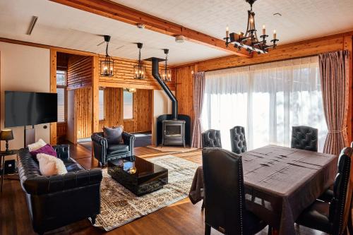 a living room with a table and a fireplace at -Light House- 那須中心エリアの道の駅から徒歩圏内で那須塩原駅からバスでも行ける完全プライベート貸切ログハウス in Nasu-yumoto