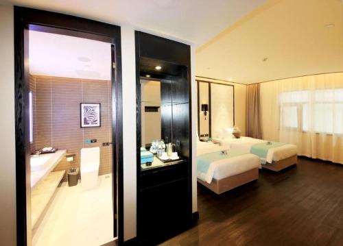 a bathroom with a bed and a bath tub next to a bedroom at Xana Hotelle·Tianshui Shangyi Plaza in Tianshui