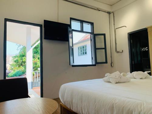 a bedroom with two beds and a table and a window at La nuit de laos in Luang Prabang