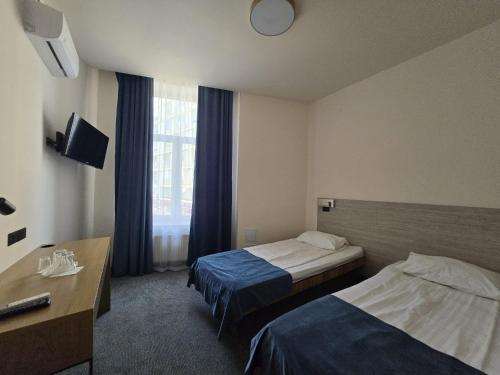 a hotel room with two beds and a window at Hotel Astoria City Center in Iaşi