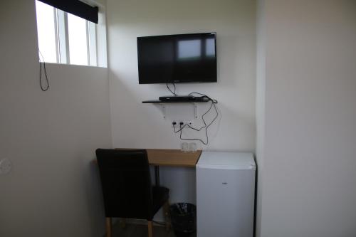 a room with a desk with a tv and a basketball hoop at Guesthouse Didi in Flagbjarnarholt