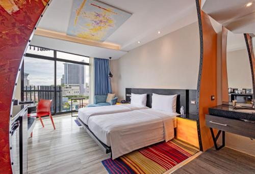 a hotel room with a bed and a mirror at Siam@Siam Design Hotel Pattaya in Pattaya Central