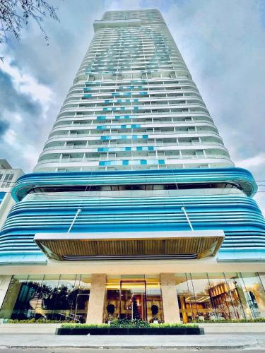 a tall building with a blue and white facade at Căn hộ TMS Pullman cao cấp Studio có ban công view biển - Golden Wave Homestay in Quy Nhon