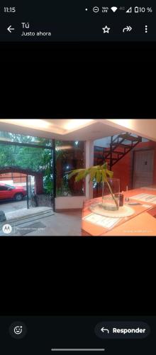 a picture of a house with a plant in front of it at Sweet Guest House in Puerto Iguazú