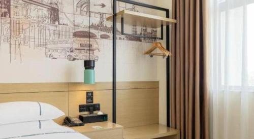 a bedroom with a bed and a desk with a lamp at City Comfort Inn Zhongxiang Mochou Avenue in Zhongxiang