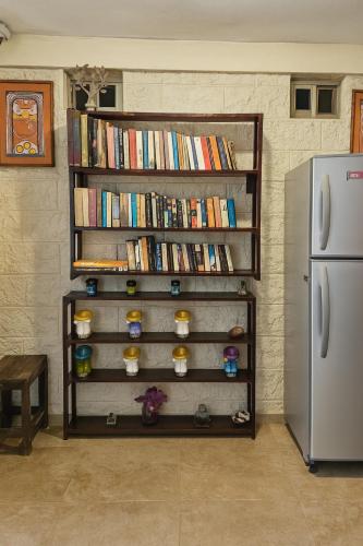 a book shelf filled with books next to a refrigerator at Hotel Papagayo in Playa del Carmen