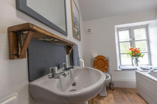 a bathroom with a sink and a mirror at Cozy Cottage, Wrington in Wrington