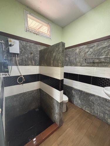 a bathroom with a tub and a toilet and a sink at Thabli Resort in Ban Song Phi Nong