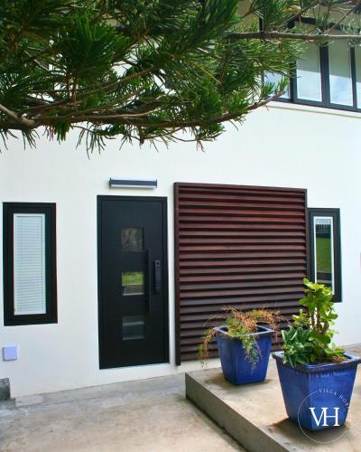 a house with a black door and two potted plants at The Triplex at Villa Horizon - Three Private Suites in Rodney Bay Village