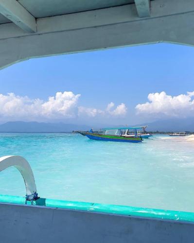 a boat in the water on a beach at Namali Villa Gili Trawangan in Gili Trawangan