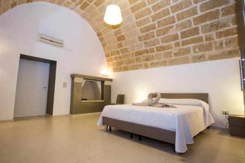 ein Schlafzimmer mit einem Bett und einer Ziegelwand in der Unterkunft Da Pippi e Gesuina in Matino