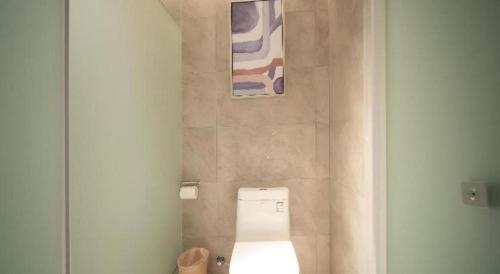 a bathroom with a toilet and two paintings on the wall at Echarm Hotel Changsha Wuyi Square Xiangya Affiliated 1st Provincial Maternity and Child in Changsha
