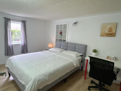 a bedroom with a large bed and a desk and a window at Vancouver Burnaby Villa 36 in Burnaby