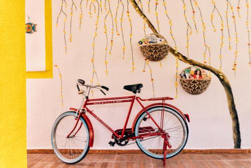 a red bike parked next to a wall with baskets at Limon Pansiyon in Foça