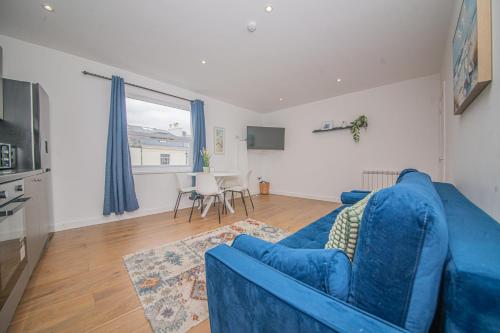 a living room with a blue couch and a table at Oxford Street Accommodation in Southampton