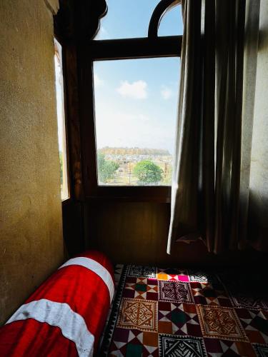 a bed in a room with a window at Golden Marigold Hotel in Jaisalmer