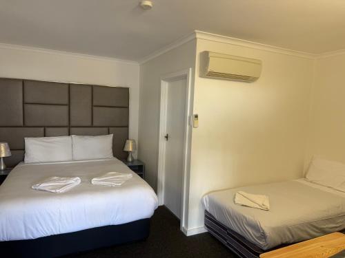 a hotel room with two beds with towels on them at Yass Motel in Yass