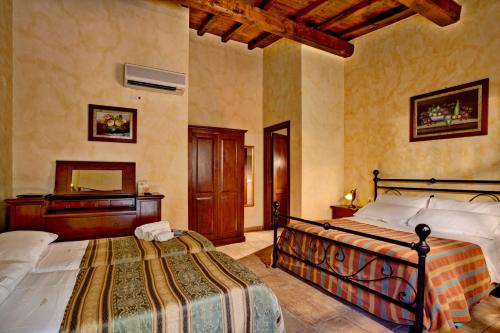 a bedroom with a bed and a dresser at Villa Hotel Valle Del Marta Resort in Tarquinia
