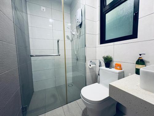 a bathroom with a shower and a toilet and a sink at Cozy Family-Friendly 3 Bedroom Condo Near IOI Mall in Putrajaya