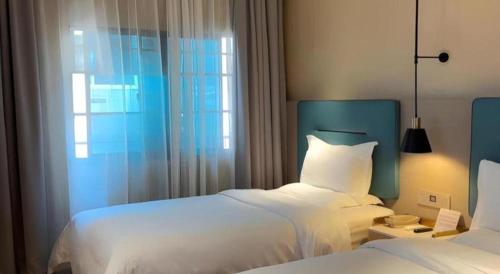 a hotel room with two beds and a window at ZMAX Hotels Shenzhen Lianhuacun Metro Station in Shenzhen