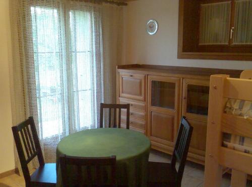 una sala da pranzo con tavolo, sedie e armadio di Chambre d'hôtes Littoral 65 a Chez-le-Bart