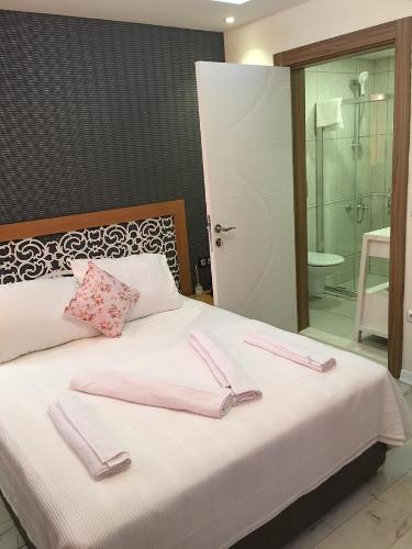 een slaapkamer met een bed met roze handdoeken bij Lila Butik Hotel Dikili in Dikili