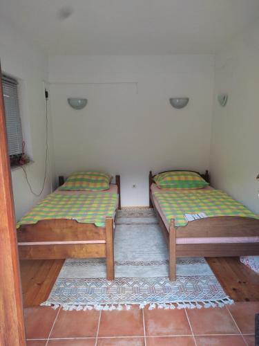 two beds sitting in a room with at Kuća za odmor sa bazenom Diva Grabovica in Jablanica