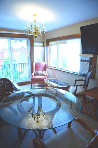 a living room with two glass tables and chairs at Noble Waterfront Suites in Brockville