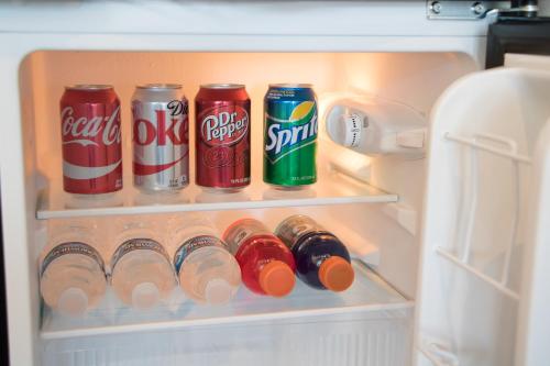 een open koelkast gevuld met blikjes en flessen frisdrank bij Skyfall Guestrooms in Green River