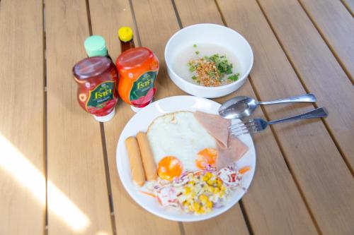 een tafel met een bord eten op een tafel bij แพในฝัน รีสอร์ท in Kanchanaburi