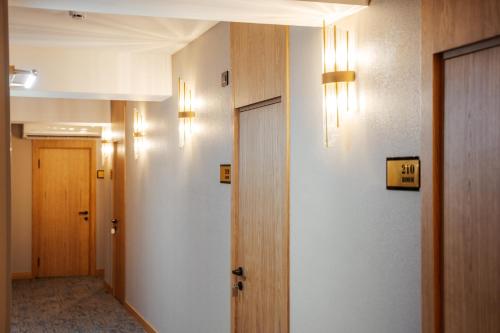 a hallway with two doors and lights on the wall at White Breeze Hotel in Baku