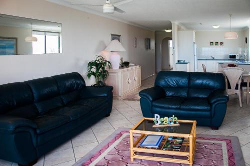 a living room with two black couches and a table at Elouera Tower in Maroochydore