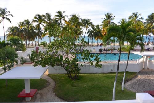 vistas a la piscina desde el balcón de un complejo en Cozy Beachfront Studio, en San Juan