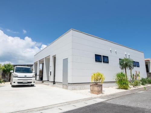 a white building with a van parked in front of it at Koahome in Miyako-jima