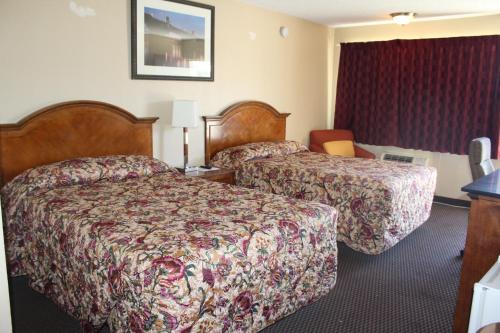 A bed or beds in a room at Cedars Inn Lewiston