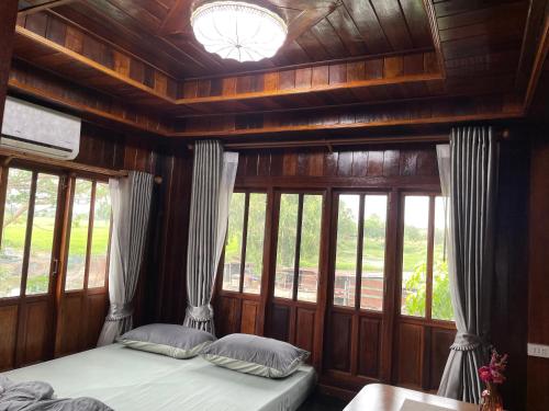 a bedroom with two beds in a room with windows at BanYat Farm Stay in Ban Bang Phae