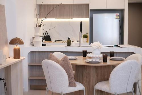 a dining room with a table and chairs and a kitchen at 'Amber' 1 bedroom apt in Burwood with free parking in Sydney