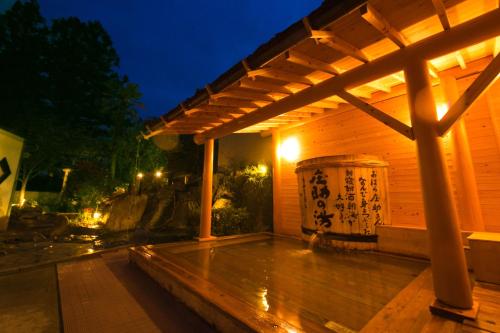 eine Holzterrasse mit einer Pergola in der Nacht in der Unterkunft Nansuikaku in Miyawaka