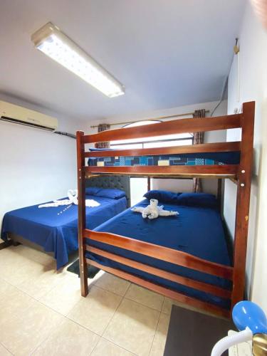 two bunk beds with blue sheets in a room at Apartamento en San Cristóbal con 2 habitaciones, 6 camas, sala, comedor, cocina, balcón privado, terraza con vista al mar, lavadora, internet satelital, cerca de bares y restaurantes - Sol y Mar, Galápagos Home in Puerto Baquerizo Moreno