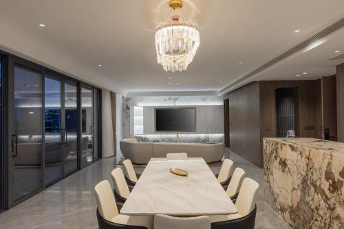 a dining room with a table and chairs and a television at Bassac Signature Hotel & Residence in Phnom Penh