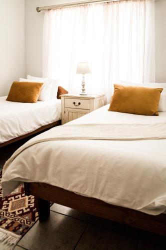 two beds in a bedroom with a window at Horizon Village 15 in Windhoek