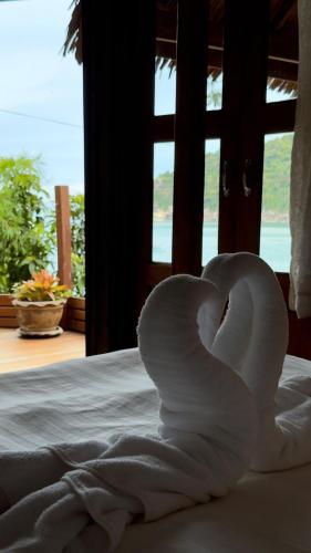ein Schwan aus Handtüchern auf einem Bett in der Unterkunft Bambu Huts in Baan Tai